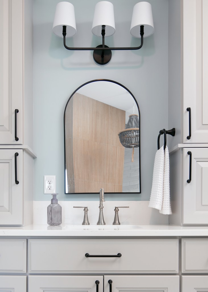 Renovated bathroom with light neutral tile, a glass shower and brushed nickel fixtures